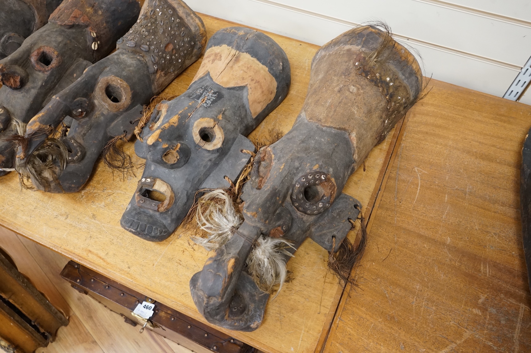 Papua New Guinea Septik River, a collection of five similar carved wooden masks of elongated form, applied in places with shells and two smaller masks with double face carving. Largest 80cm high.